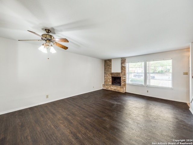 unfurnished living room with a fireplace, ceiling fan, and dark wood-type flooring