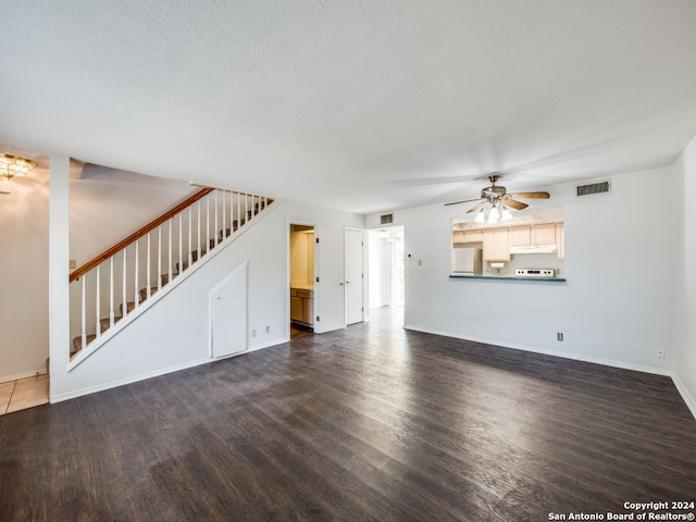 unfurnished living room with ceiling fan, a textured ceiling, and dark wood-type flooring