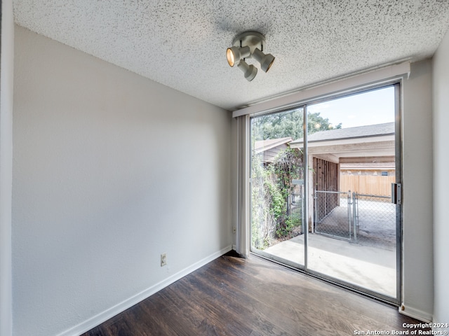 unfurnished room with dark hardwood / wood-style floors and a textured ceiling