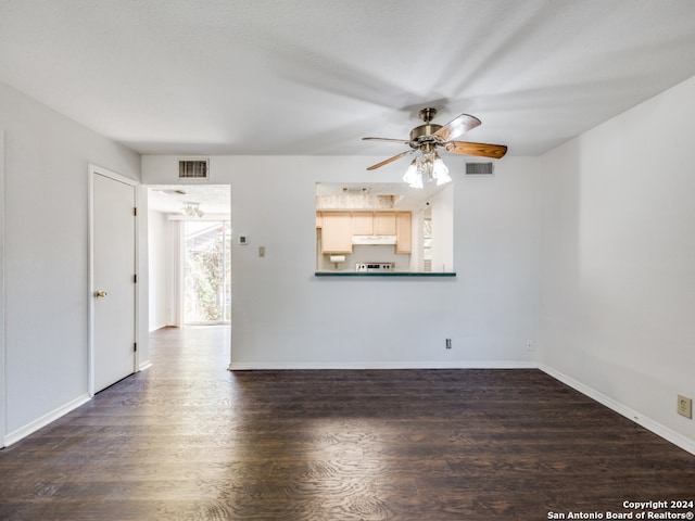 unfurnished living room with ceiling fan and dark wood-type flooring