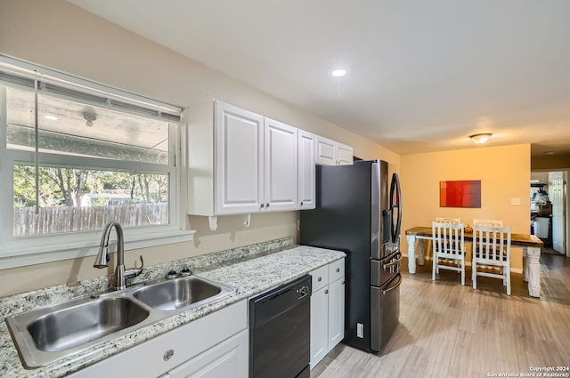 kitchen featuring black dishwasher, white cabinetry, light wood-type flooring, stainless steel refrigerator with ice dispenser, and sink