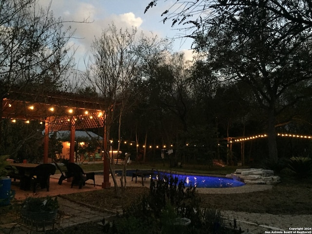 pool at dusk with a patio area