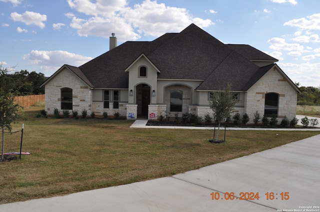 french country inspired facade with a front lawn