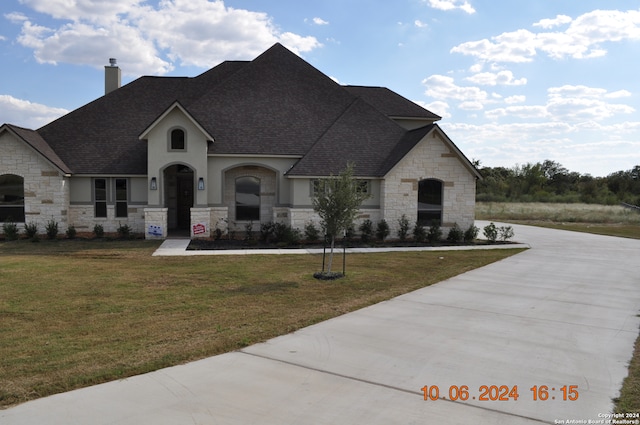 french country home featuring a front yard