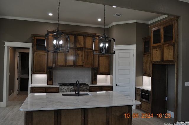 kitchen with pendant lighting, sink, and light stone counters