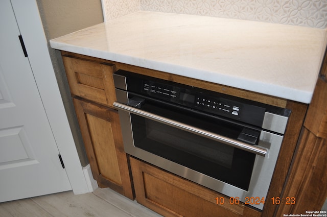 details with stainless steel oven and light hardwood / wood-style floors