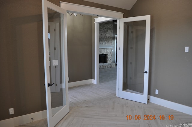 interior space featuring french doors, vaulted ceiling, and light parquet flooring