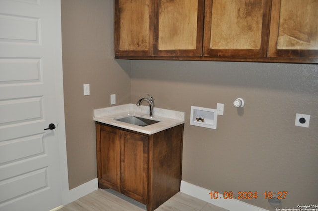 washroom with washer hookup, hookup for an electric dryer, sink, and cabinets