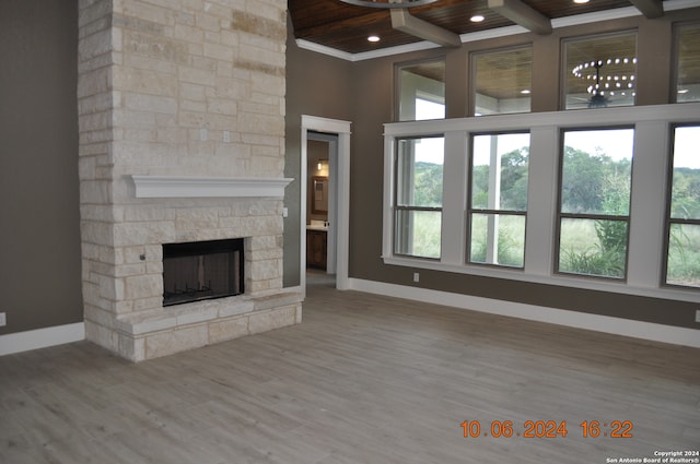 unfurnished living room with light wood-type flooring, wood ceiling, plenty of natural light, and a fireplace