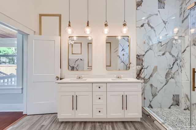 bathroom featuring vanity, wood-type flooring, and tiled shower