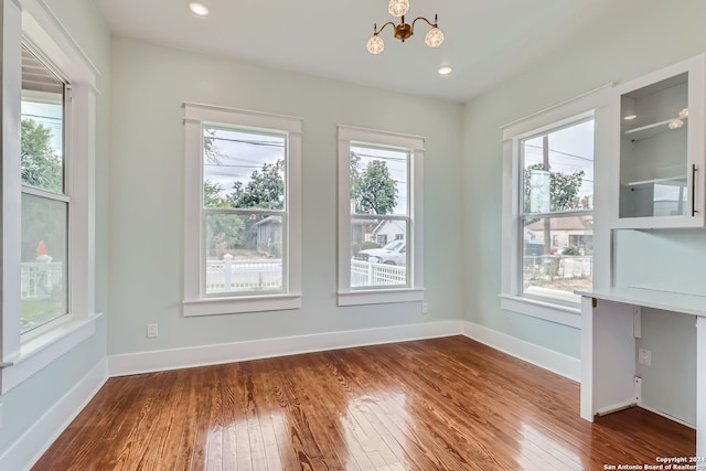 unfurnished dining area with a healthy amount of sunlight and hardwood / wood-style flooring