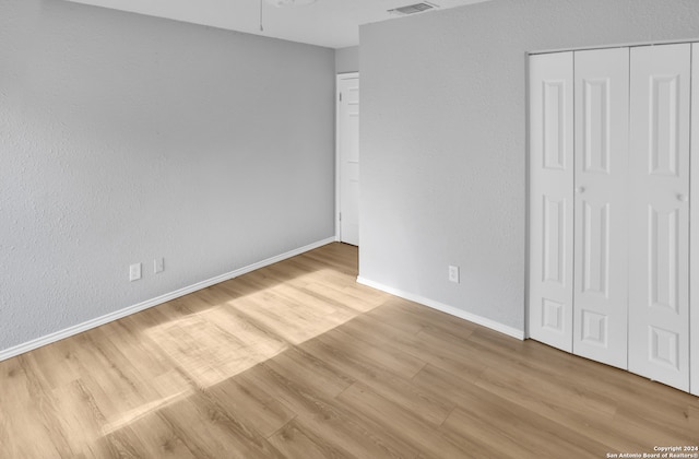 unfurnished bedroom featuring a closet and light wood-type flooring