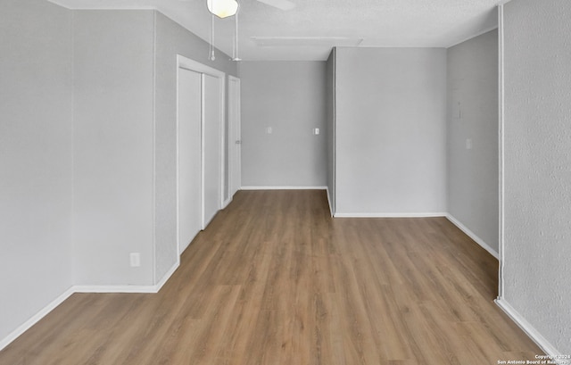 spare room featuring light hardwood / wood-style floors, a textured ceiling, and ceiling fan