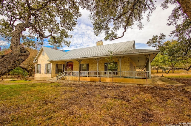 farmhouse-style home with covered porch and a front lawn