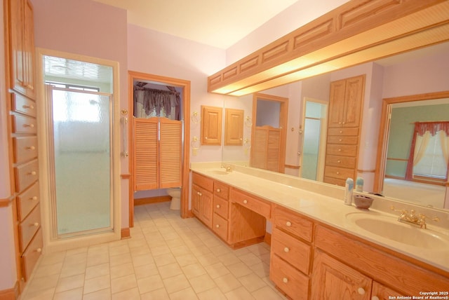 bathroom with toilet, vanity, tile patterned flooring, and a shower with shower door