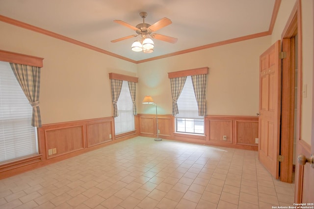 spare room with ceiling fan, light tile patterned floors, and crown molding