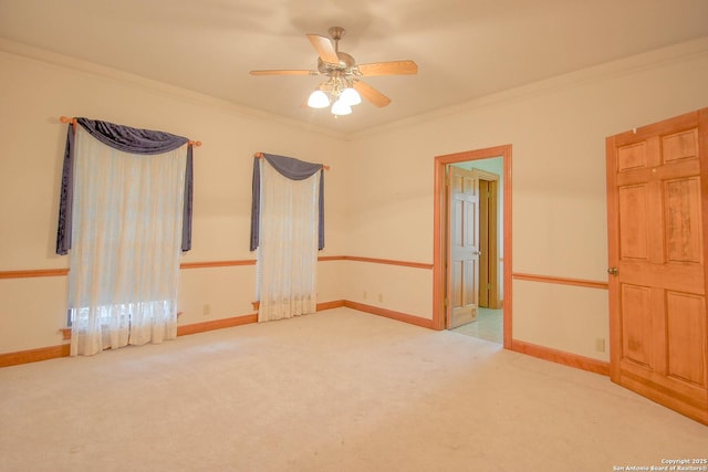 unfurnished room featuring ceiling fan, light carpet, and ornamental molding