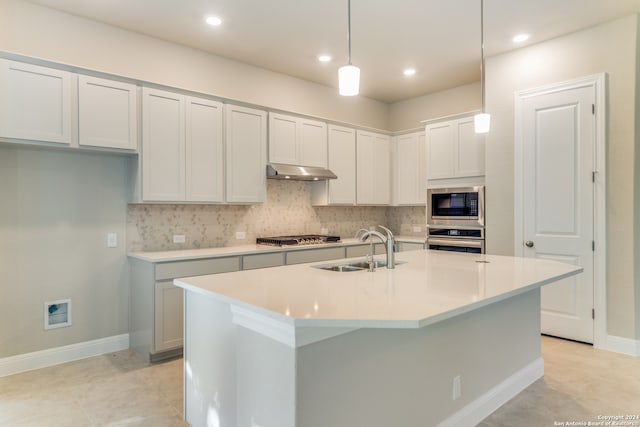 kitchen with pendant lighting, sink, a center island with sink, backsplash, and stainless steel appliances