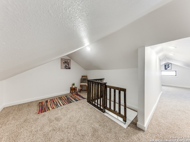 bonus room with light carpet, a textured ceiling, and lofted ceiling