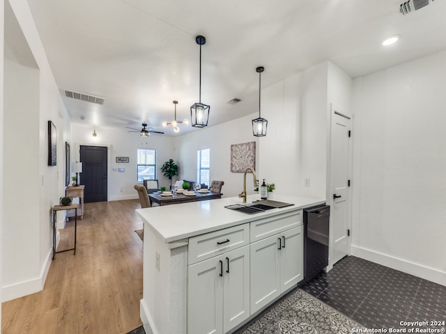 kitchen with hanging light fixtures, kitchen peninsula, black dishwasher, and white cabinetry