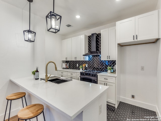 kitchen with sink, wall chimney range hood, white cabinetry, hanging light fixtures, and electric range