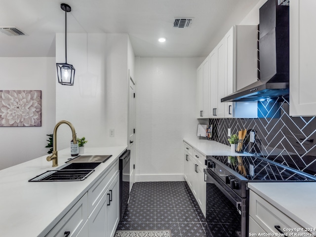 kitchen featuring white cabinets, hanging light fixtures, tasteful backsplash, stainless steel electric range, and wall chimney range hood