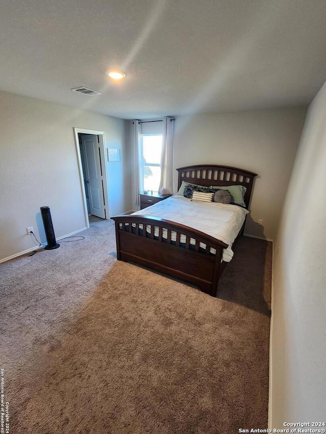 bedroom featuring a textured ceiling and carpet flooring