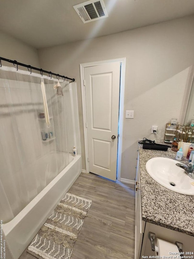 bathroom featuring shower / bath combination with curtain, hardwood / wood-style flooring, and vanity