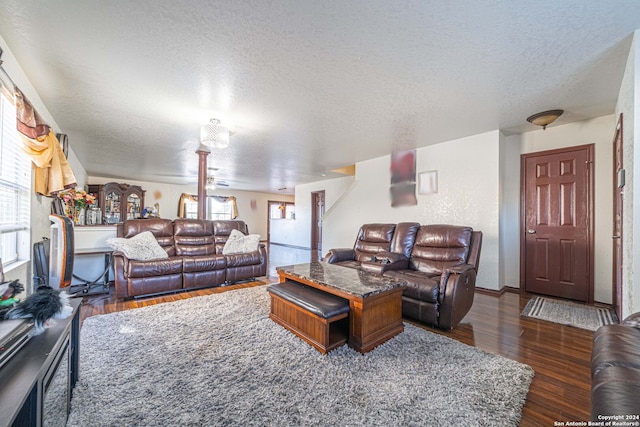 living room featuring a textured ceiling and dark hardwood / wood-style floors