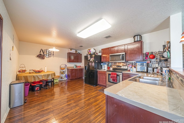 kitchen with sink, hanging light fixtures, dark hardwood / wood-style floors, a textured ceiling, and appliances with stainless steel finishes