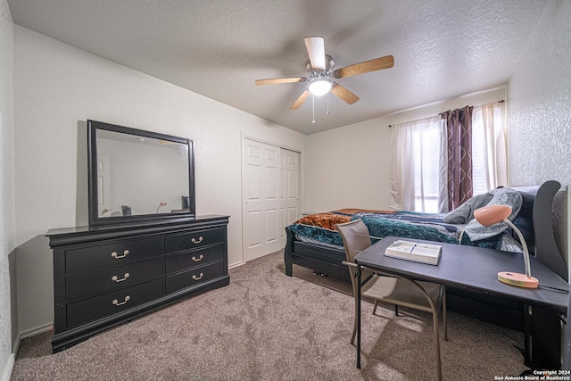 carpeted bedroom featuring ceiling fan, a textured ceiling, and a closet