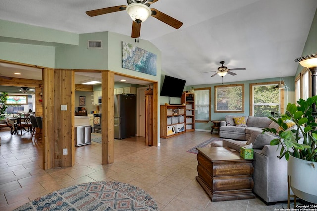 living room featuring ceiling fan, light tile patterned flooring, and vaulted ceiling