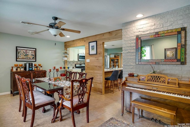 dining area featuring wooden walls and ceiling fan