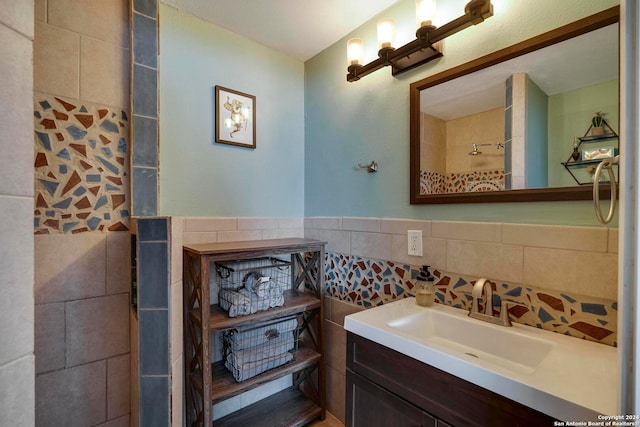 bathroom featuring a tile shower, vanity, and tile walls