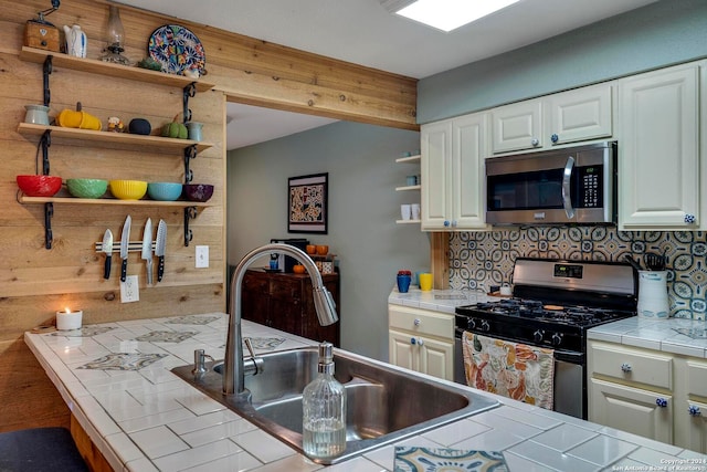 kitchen featuring white cabinets, sink, tasteful backsplash, appliances with stainless steel finishes, and tile countertops