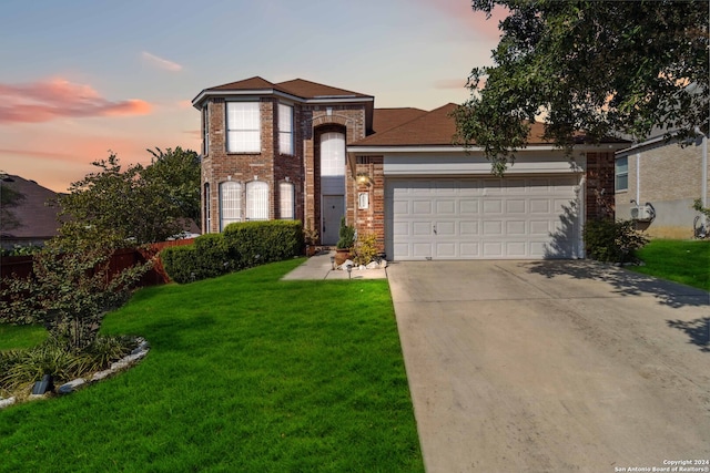 view of front of property featuring a garage and a lawn