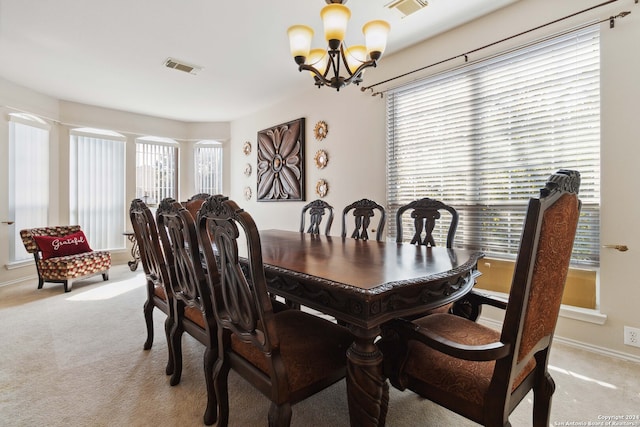 dining area featuring a notable chandelier, a healthy amount of sunlight, and light colored carpet