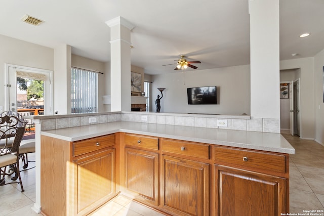 kitchen featuring ornate columns, light tile patterned flooring, and ceiling fan