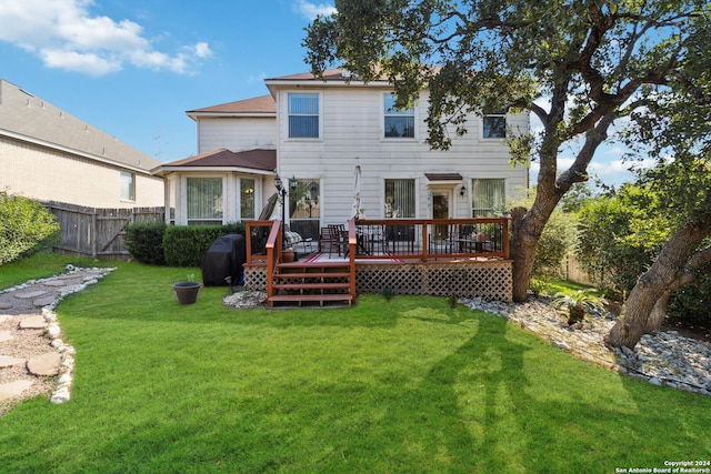 back of house with a deck and a lawn