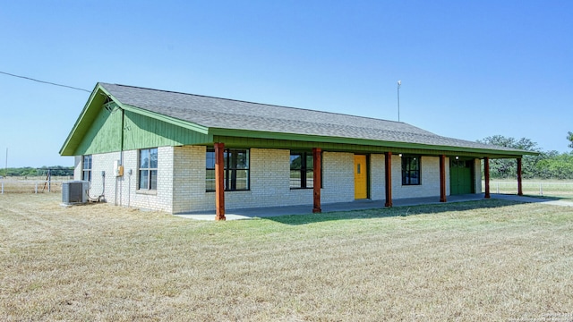 view of front of house featuring central air condition unit and a front yard