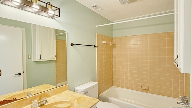 full bathroom featuring a textured ceiling, vanity, toilet, and tiled shower / bath combo