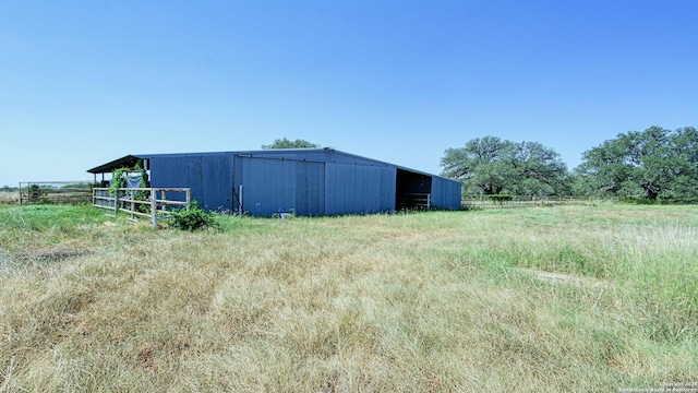 view of yard with a rural view and an outdoor structure