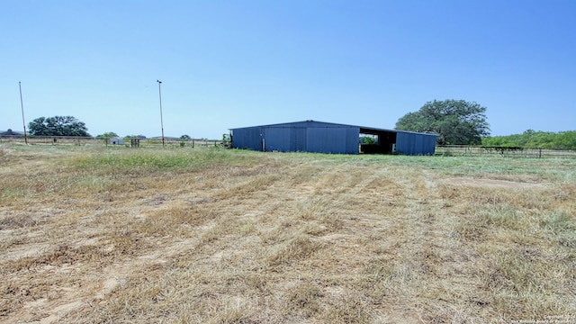 view of yard with a rural view and an outdoor structure