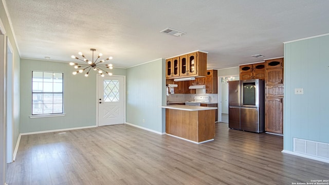 kitchen featuring stainless steel fridge, kitchen peninsula, tasteful backsplash, hardwood / wood-style floors, and white range with electric stovetop