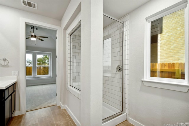 bathroom featuring vanity, ceiling fan, and a shower with door