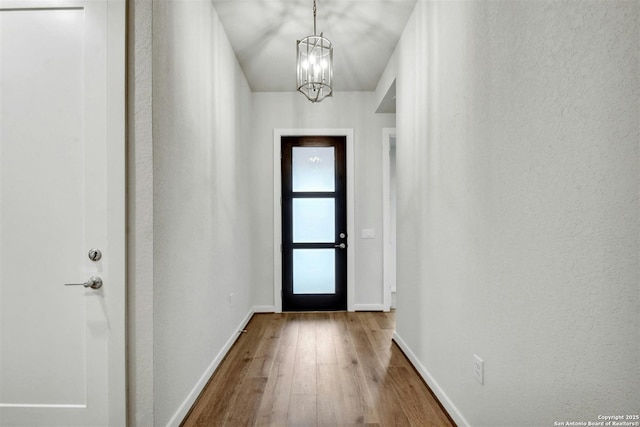 entryway featuring hardwood / wood-style floors and a notable chandelier