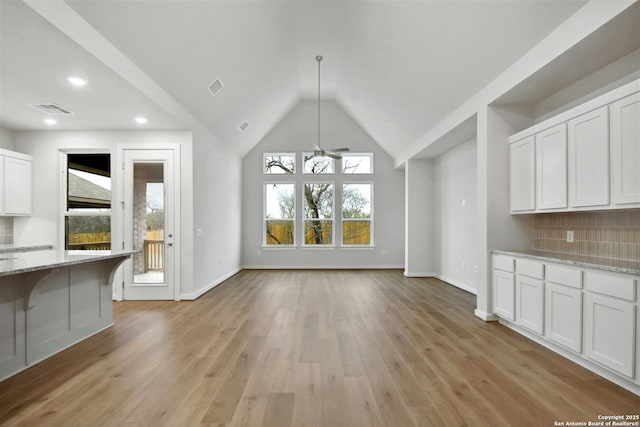 unfurnished dining area with ceiling fan, lofted ceiling, and light hardwood / wood-style flooring