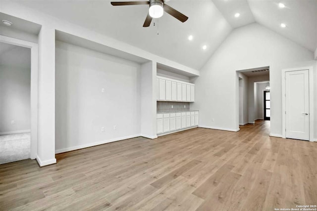 unfurnished living room featuring ceiling fan, high vaulted ceiling, and light hardwood / wood-style floors