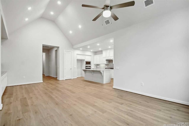 unfurnished living room featuring sink, high vaulted ceiling, ceiling fan, and light wood-type flooring