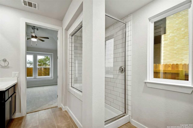 bathroom featuring vanity, ceiling fan, and a shower with shower door